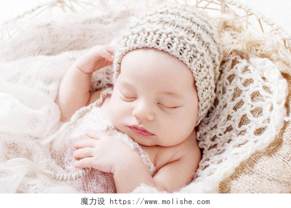 躺在摇篮时睡觉的儿童甜美的新生婴儿睡觉。3周大的新生男孩躺在篮子里用针织格子。漂亮的新生男孩的肖像。特写图像